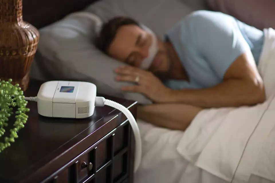 CPAP mask and sleep therapy supplies on a bedside table